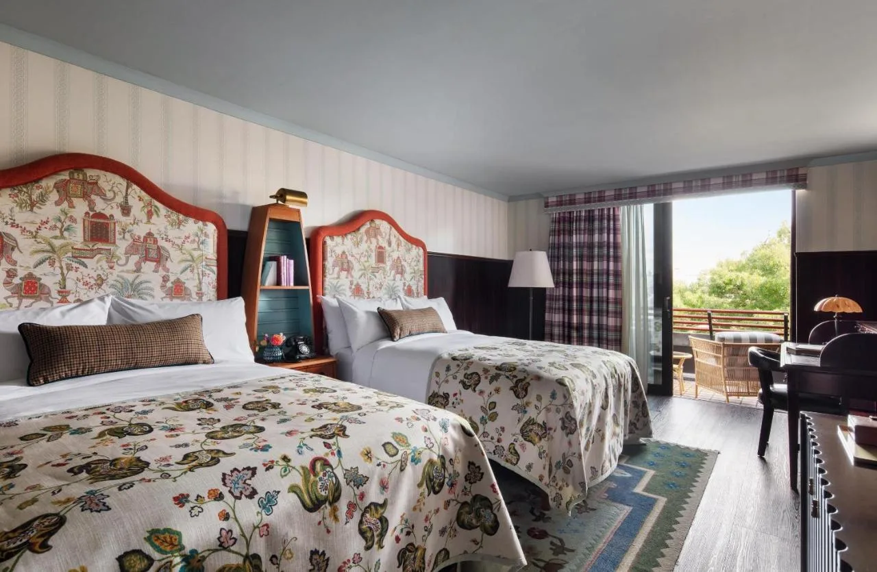 a hotel room with two beds and a balcony at Graduate by Hilton Cambridge in Cambridge